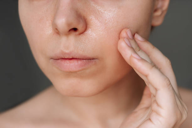 Close-up of a person examining their facial skin