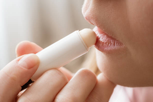 Woman applying lip balm close-up