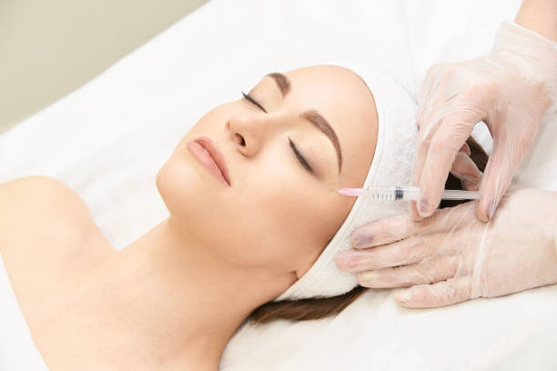 Woman receiving facial treatment with a syringe at a spa