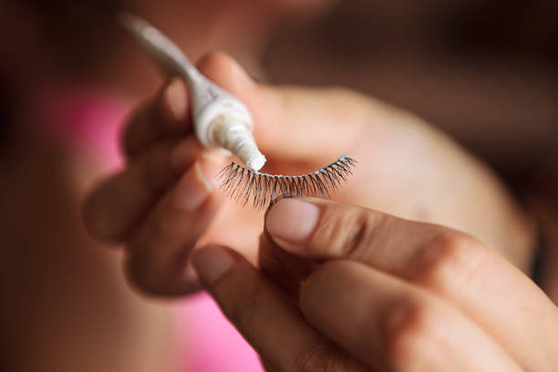 Applying adhesive to false eyelashes close-up