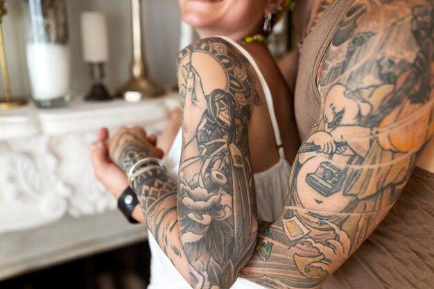 Tattooed arms of a person leaning on a ledge close-up